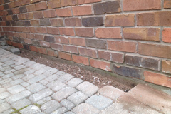 Bottom course of bricks removed and replaced with matching bricks - After
